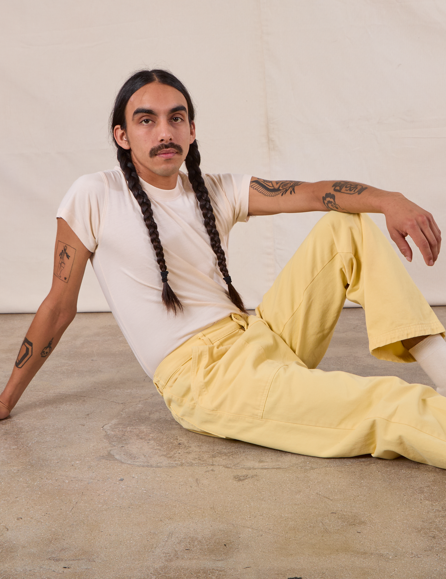 Anthony is wearing Work Pants in Butter Yellow paired with an Organic Vintage Tee in Vintage Tee Off-White