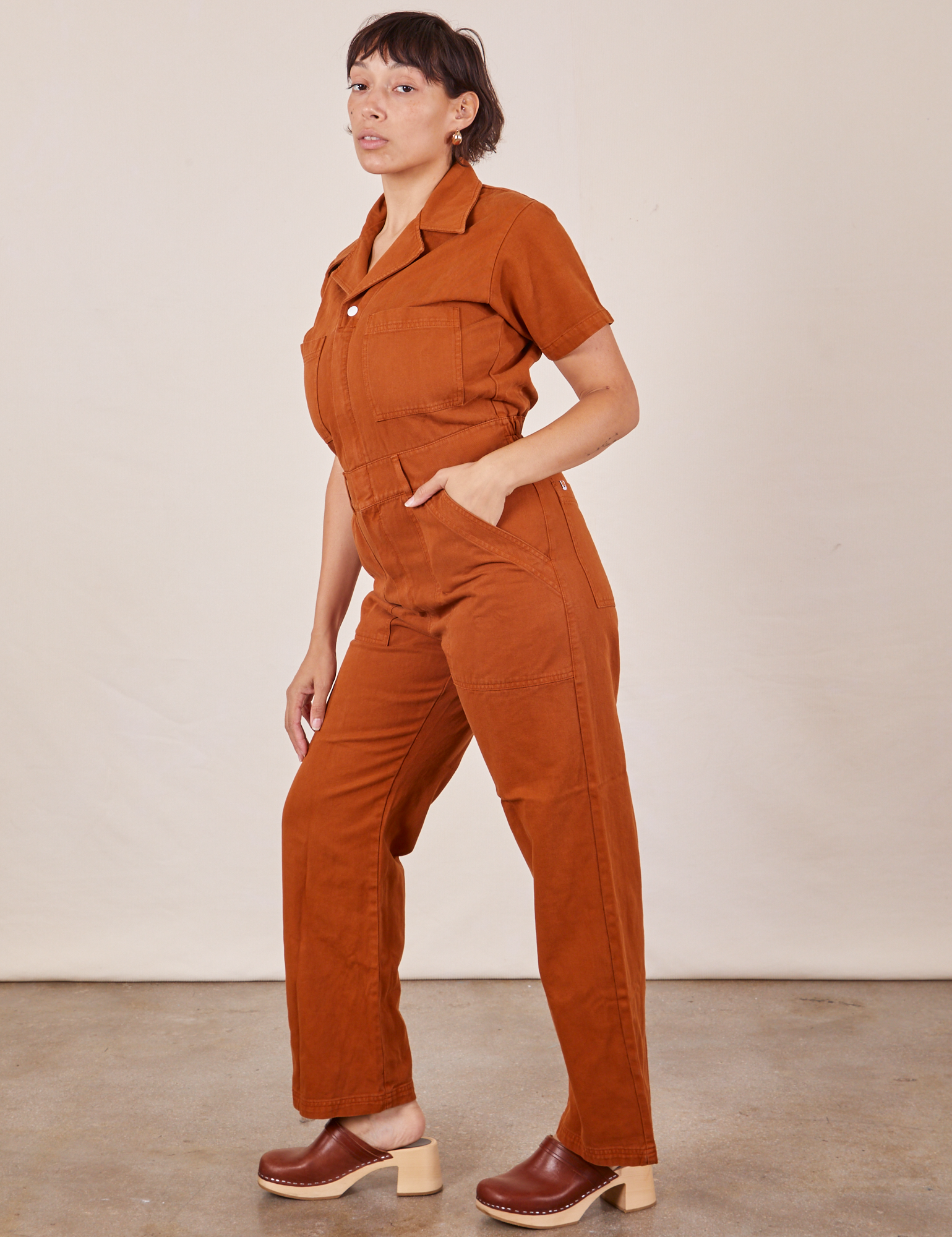 Side view of Short Sleeve Jumpsuit in Burnt Terracotta worn by Tiara
