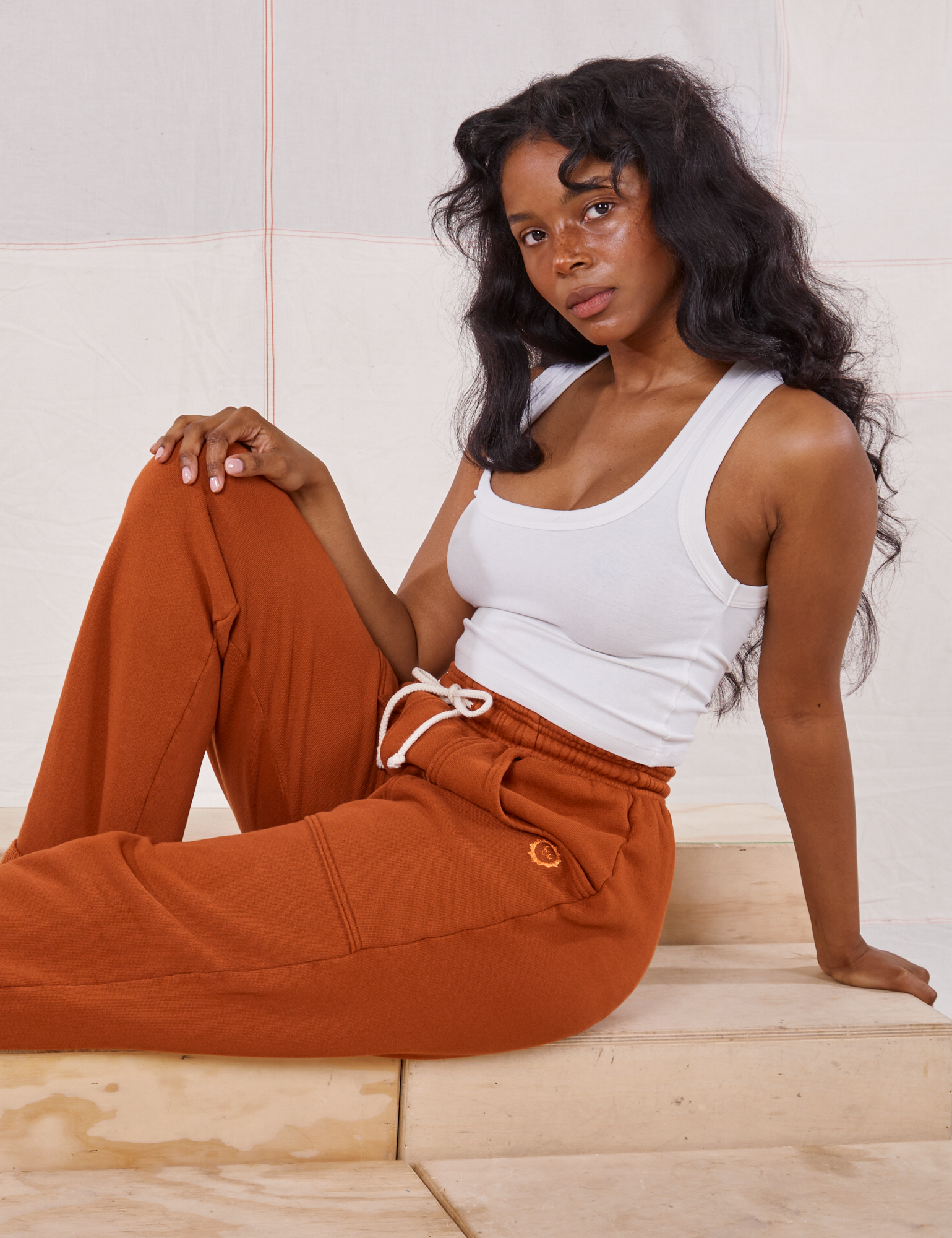 Kandia is wearing Rolled Cuff Sweat Pants in Burnt Terracotta and vintage off-white Cropped Tank
