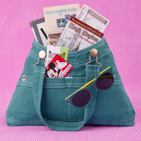 Overall Handbag in Marine Blue. Magic Kingdom brochures inside main compartment. Disney gift card in front pocket and sunglasses