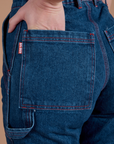 Close up of Alex's hand in the back pocket of Carpenter Jeans in Dark Wash