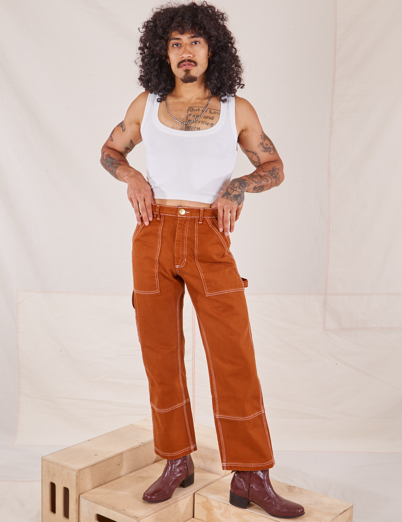 Jesse is 5&#39;8&quot; and wearing XS Carpenter Jeans in Burnt Terracotta paired with a vintage off-white Cropped Tank Top