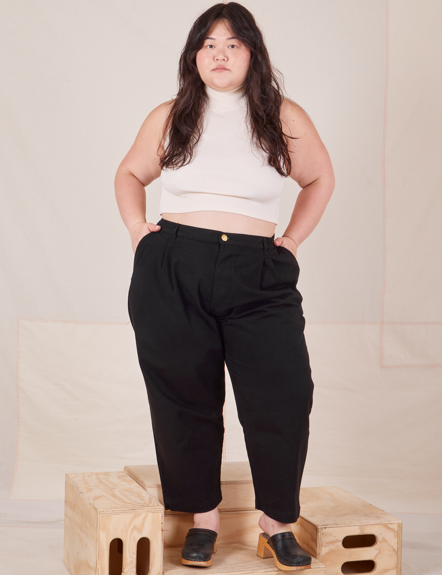 Ashley is 5&#39;7&quot; and wearing 1XL Petite Heavyweight Trousers in Basic Black paired with Sleeveless Turtleneck in vintage tee off-white 