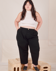 Ashley is 5'7" and wearing 1XL Petite Heavyweight Trousers in Basic Black paired with Sleeveless Turtleneck in vintage tee off-white