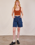 Margaret is 5'11" and wearing XS  Carpenter Shorts in Dark Wash paired with burnt terracotta Cropped Tank