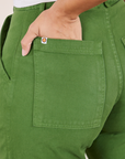Pencil Pants in Lawn Green back pocket close up. Tiara has her hand in the pocket.