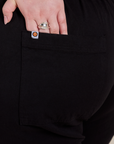 Close up of Ashley's hand in the back pocket of Short Sleeve Jumpsuit in Basic Black