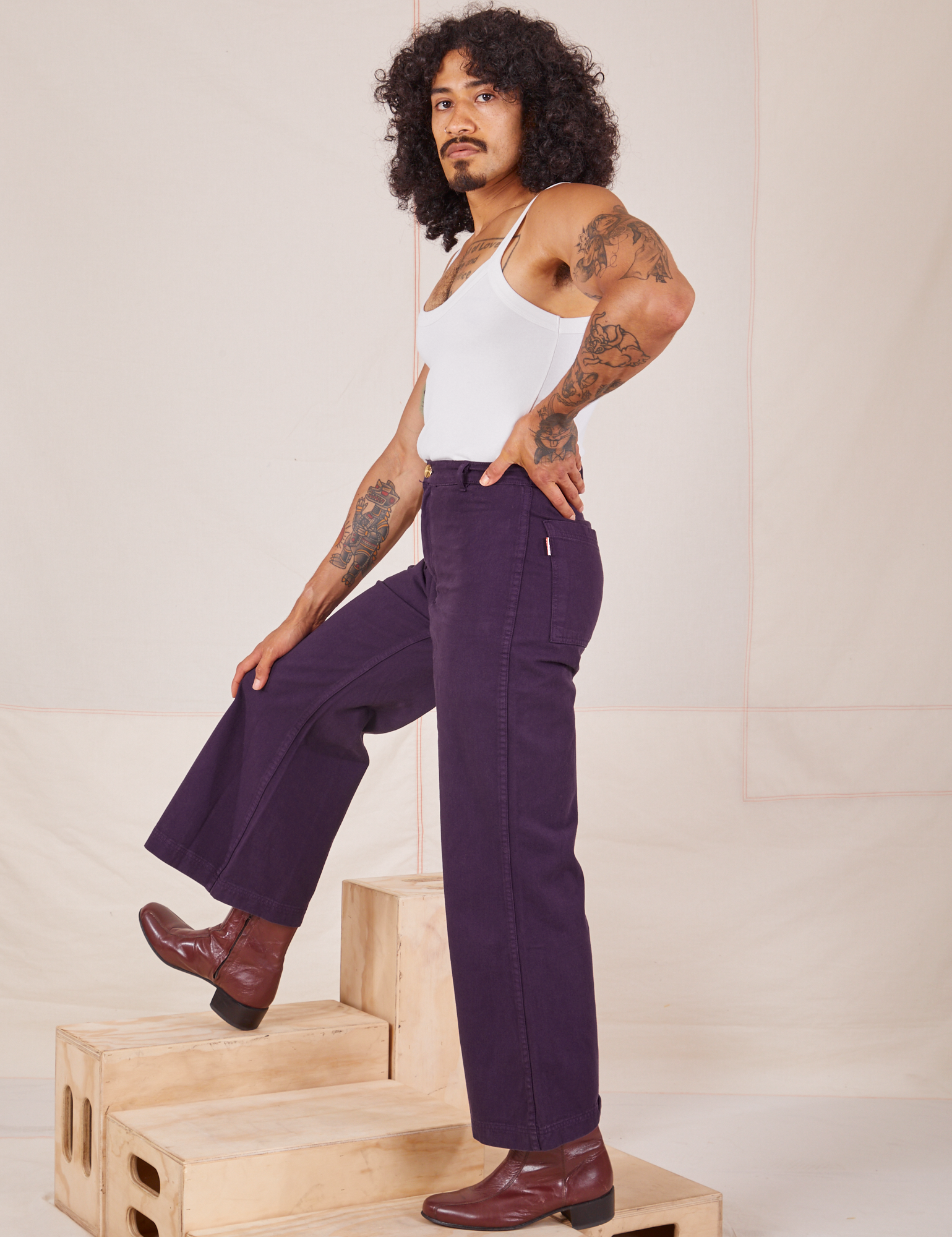 Side view of Bell Bottoms in Nebula Purple and Cropped Cami in vintage tee off-white worn by Jesse