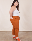 Side view of Petite Pencil Pants in Burnt Terracotta and Cropped Cami in vintage tee off-white on Ashley