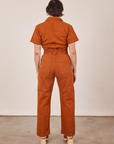 Back view of Short Sleeve Jumpsuit in Burnt Terracotta worn by Tiara