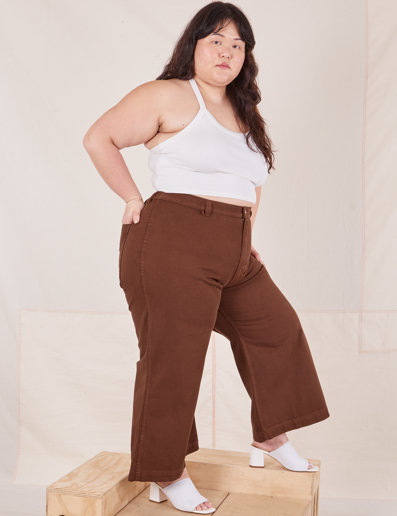 Side view of Petite Bell Bottoms in Fudgesicle Brown and vintage off-white Cami on Ashley