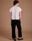Back view of Carpenter Jeans in Black and the Organic Vintage Tee in Vintage Tee Off-White on Quinn