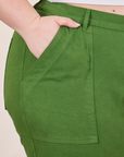 Petite Pencil Pants in Lawn Green front pocket close up. Ashley has her hand in the pocket.