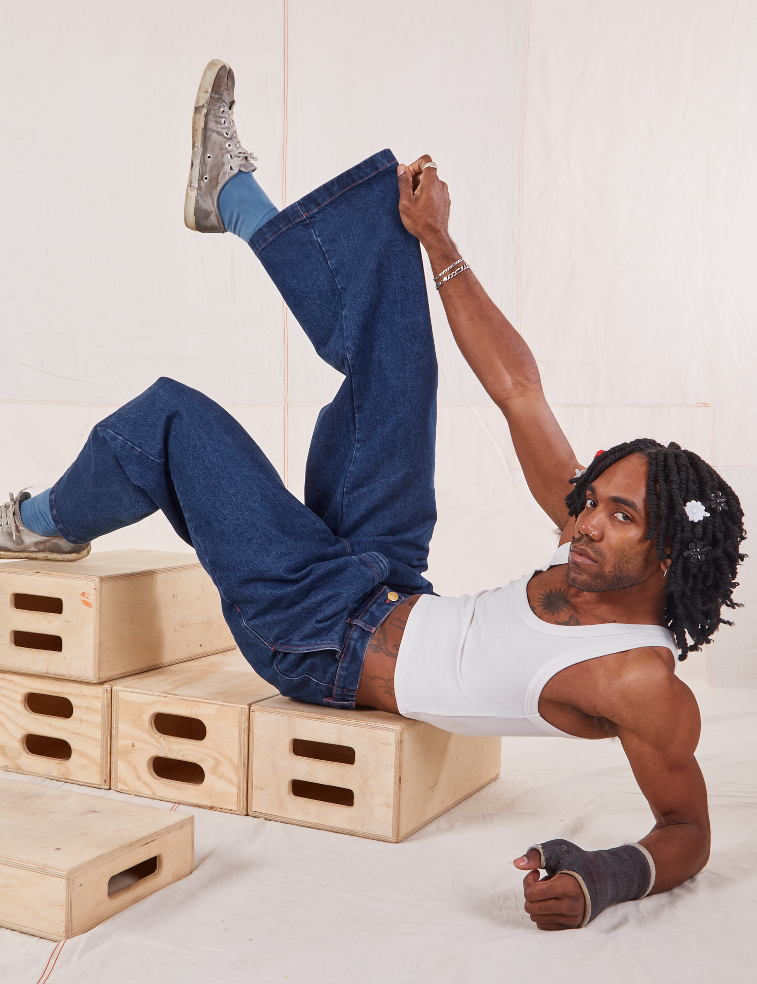Jerrod is wearing Indigo Wide Leg Trousers in Dark Wash and vintage off-white Cropped Tank Top