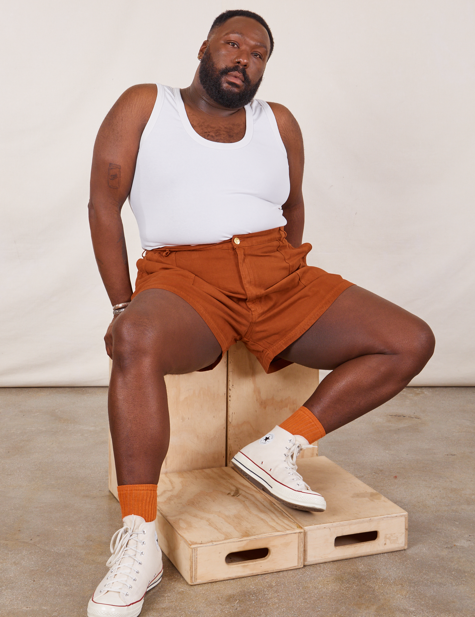 Elijah is wearing Classic Work Shorts in Burnt Terracotta and Cropped Tank Top in vintage tee off-white