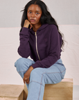 Kandia is wearing Cropped Zip Hoodie in Nebula Purple and light wash Carpenter Jeans