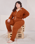 Ashley is wearing Cropped Zip Hoodie in Burnt Terracotta and matching Rolled Cuff Sweat Pants