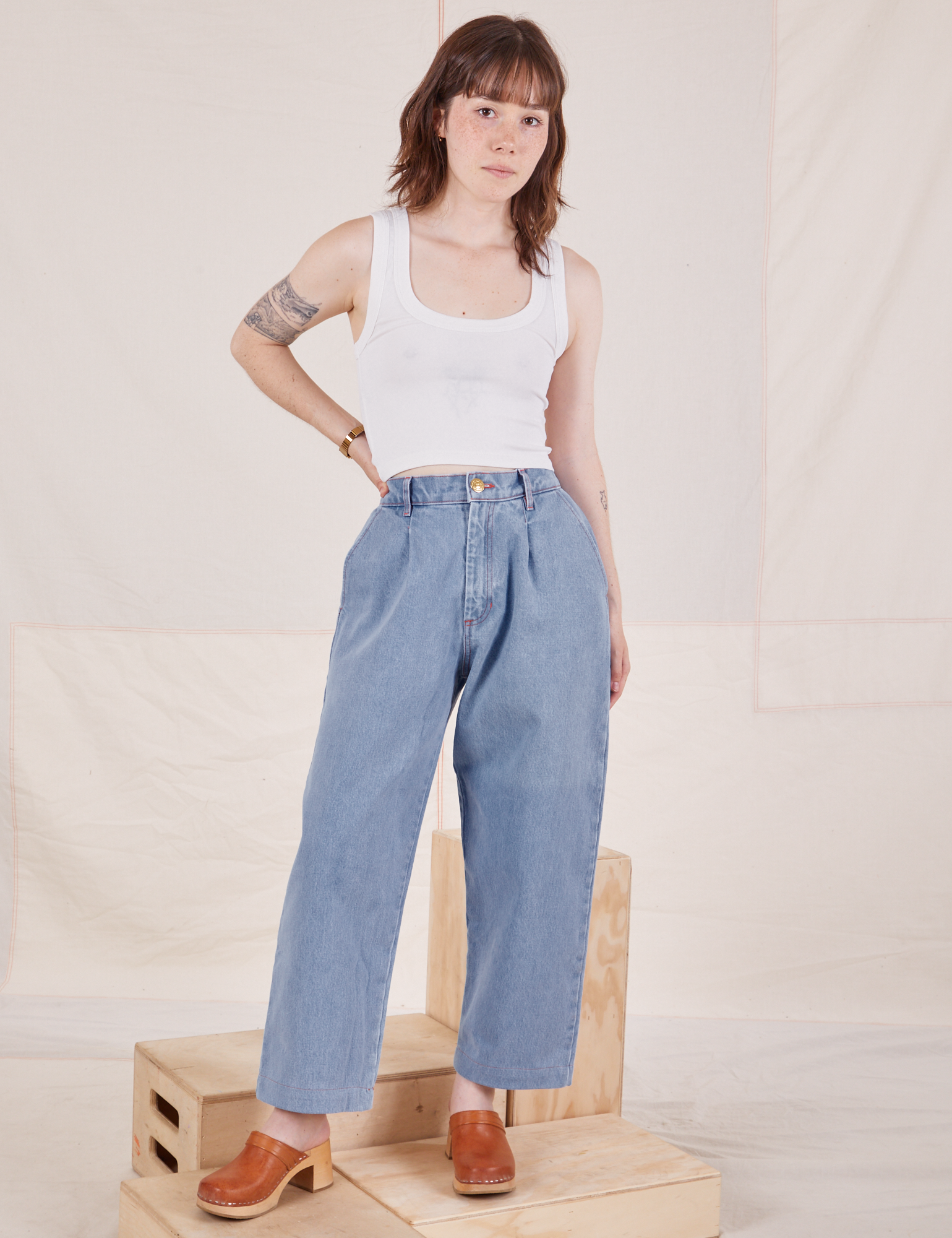 Hana is 5&#39;3&quot; and wearing XXS Petite Denim Trouser Jeans in Light Wash paired with Cropped Tank Top in vintage tee off-white t
