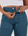 Petite Work Pants in Lagoon front close up. Kandia is pulling down on the zipper tab