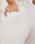 Back pocket close up of Short Sleeve Jumpsuit in Vintage Tee Off-White. Tiara has her hand in the pocket.