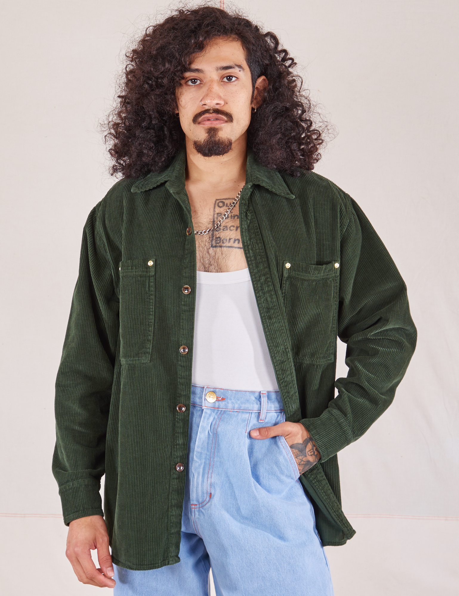 Jesse is wearing Corduroy Overshirt in Swamp Green with a vintage off-white Cropped Tank underneath paired with light wash Denim Trouser Jeans