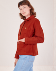 Side view of Denim Work Jacket in Paprika worn by Alex. She has her hand in the front pocket.