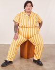 Sam is sitting on a wooden box wearing Lemon Stripe Jumpsuit