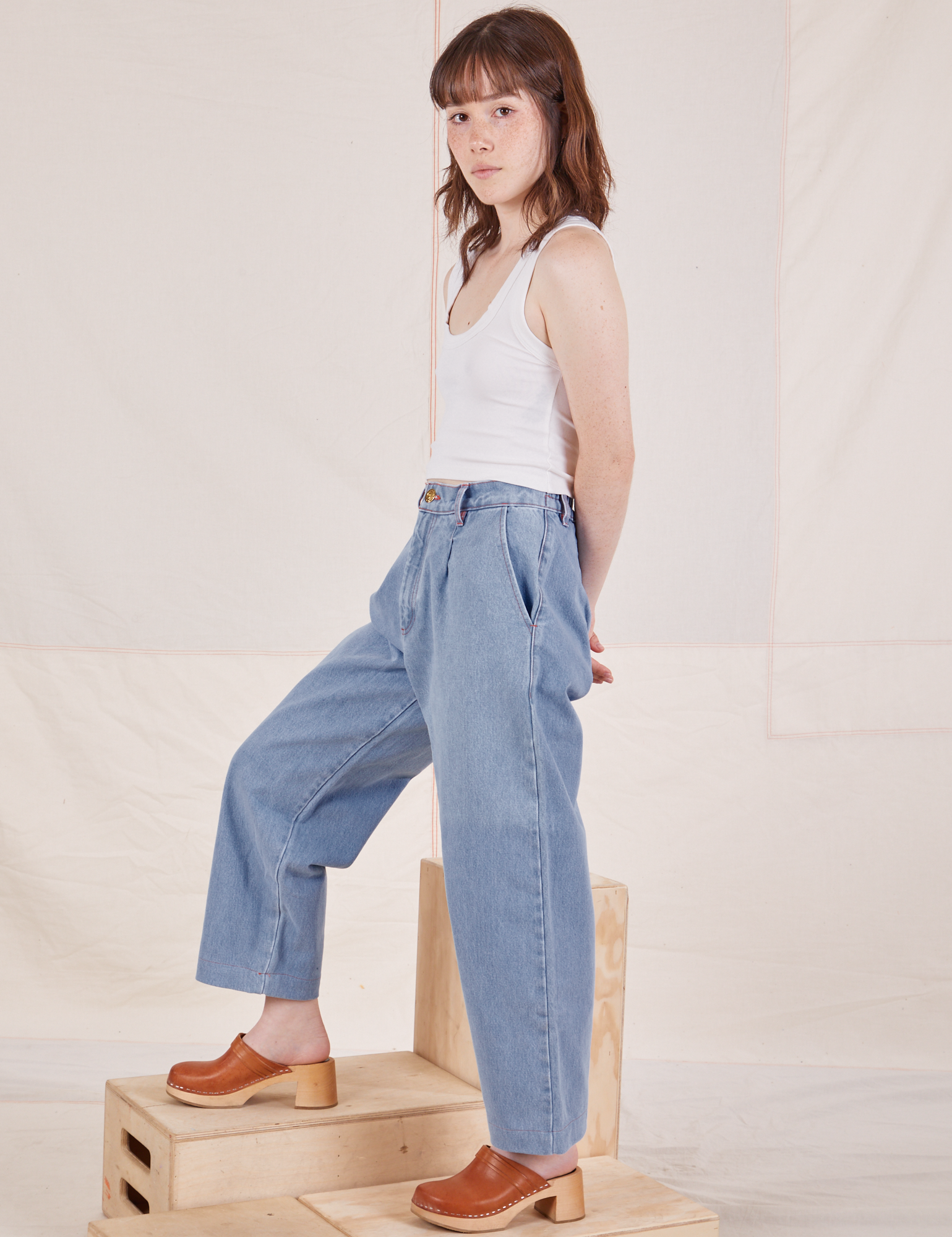 Side view of Denim Trouser Jeans in Light Wash and Cropped Tank Top in vintage tee off-white on Hana