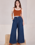 Hana is 5'3" and wearing P Petite Indigo Wide Leg Trousers in Dark Wash and burnt terracotta Cami