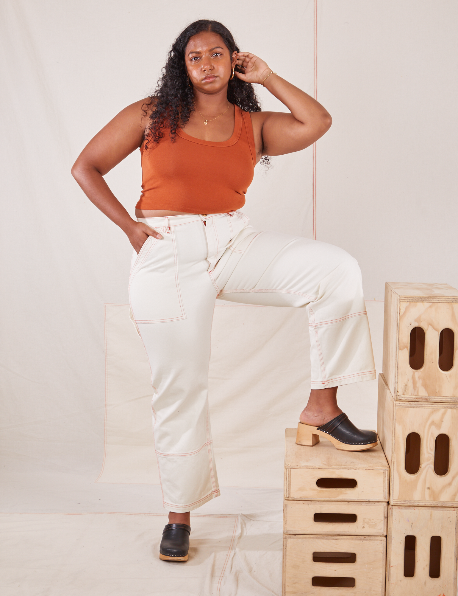 Meghna is wearing Carpenter Jeans in Vintage Tee Off-White and burnt terracotta Cropped Tank Top