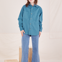 Hana is wearing a buttoned up Oversize Overshirt in Marine Blue and light wash Sailor Jeans