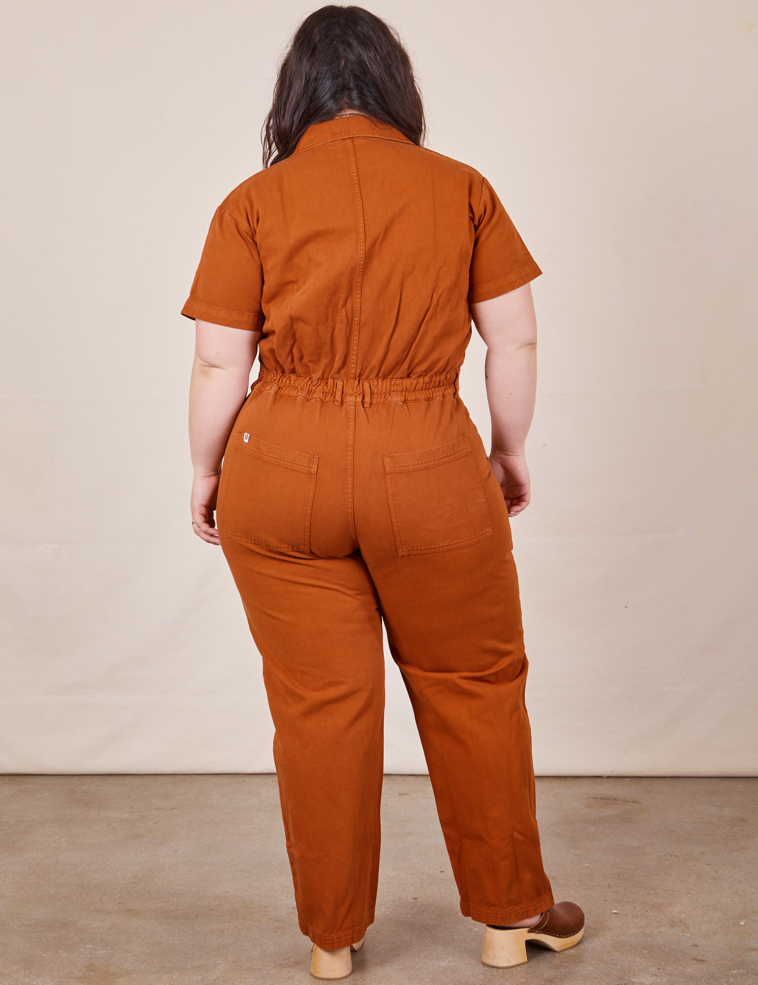 Back view of Short Sleeve Jumpsuit in Burnt Terracotta worn by Ashley