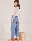 Angled back view of Denim Trouser Jeans in Light Wash and vintage off-white Cropped Tank Top on Hana