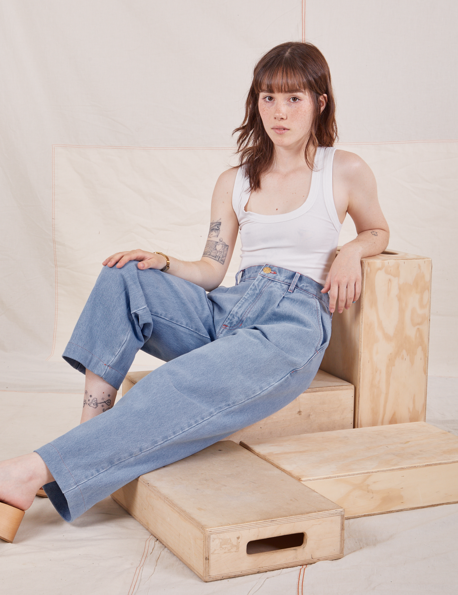 Hana is wearing Denim Trouser Jeans in Light Wash and Cropped Tank Top in vintage tee off-white