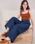 Hana is wearing Indigo Wide Leg Trousers in Dark Wash and burnt terracotta Cropped Cami