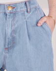 Indigo Wide Leg Petite Trousers in Light Wash front close up. Hana has her hand in the pocket.