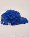 Side view of Dugout Corduroy Hat in Royal Blue. Big Bud label sewn on edge of hat.
