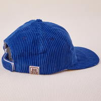 Side view of Dugout Corduroy Hat in Royal Blue. Big Bud label sewn on edge of hat.