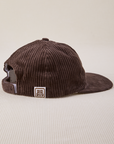 Side view of Dugout Corduroy Hat in Espresso Brown. Big Bud label sewn on edge of hat.