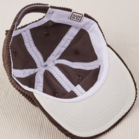 Dugout Corduroy Hat in Espresso Brown flipped over. White satin under-bill.
