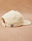 Side view of Dugout Corduroy Hat in Vintage Off-White. Big Bud label sewn onto edge of hat.