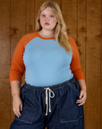 Juliet is wearing the Baby Blue/Orange Colorblock Raglan Tee