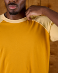 Close up of the neckline of the Mustard Yellow/Butter Raglan Tee on Isaac