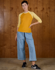 Alex is 5'8" and wearing P Mustard Yellow/Butter Raglan Tee untucked with Light Wash Denim Drop Pocket Pants