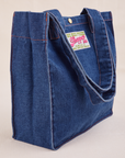 Angled view of Denim Shopper Tote Bag in Dark Wash