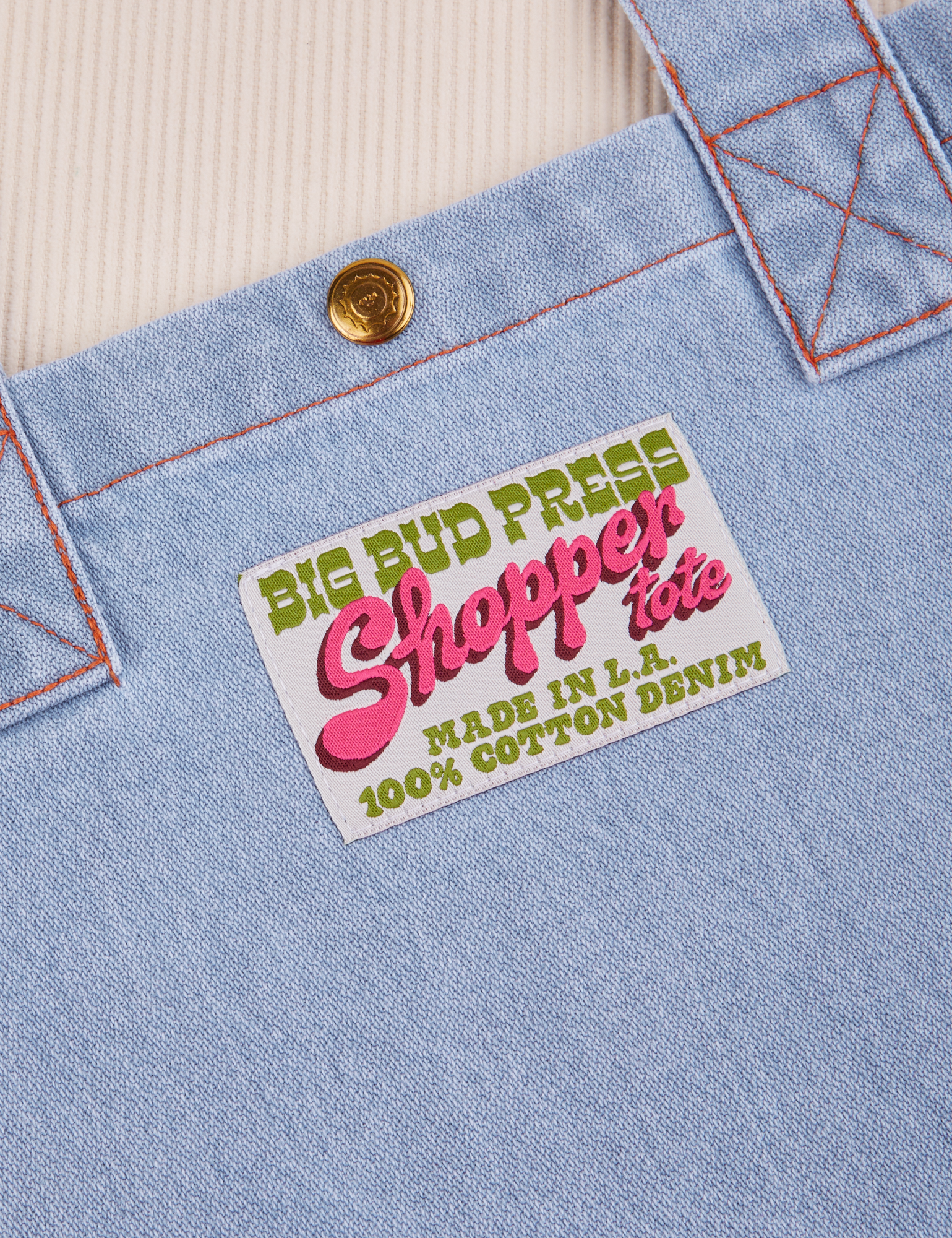 Denim Shopper Tote Bag label close up that reads: Big Bud Press Shopper Tote. Made in LA. 100% Cotton Denim.