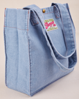 Angled view of Denim Shopper Tote Bag in Light Wash