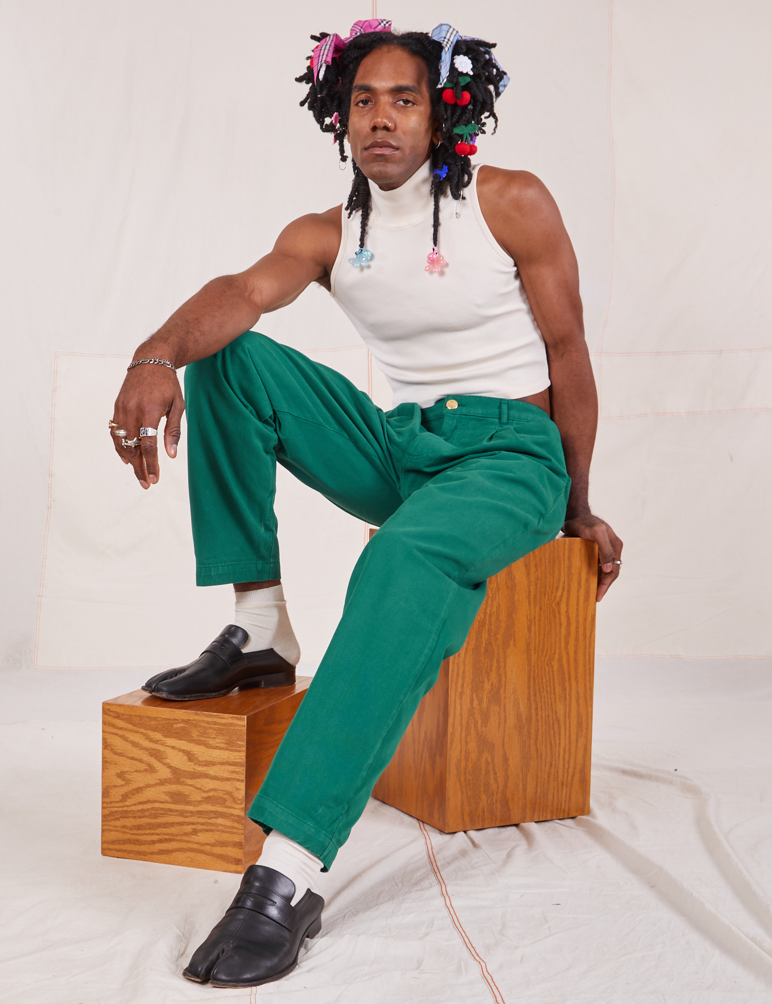 Jerrod is wearing Heavyweight Trousers in Hunter Green and Sleeveless Turtleneck in vintage tee off-white