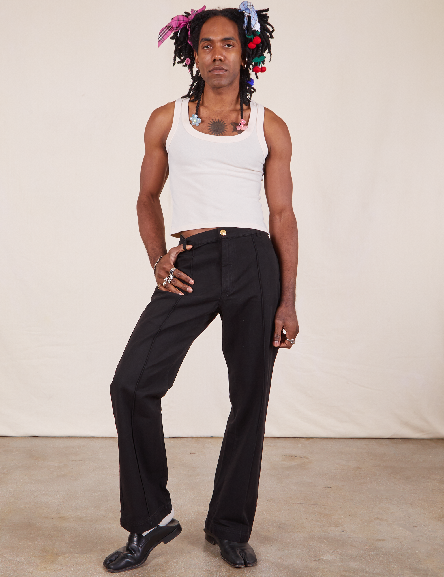 Jerrod is 6&#39;3&quot; and wearing M Long Western Pants in Basic Black paired with Tank Top in vintage tee off-white 