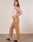 Side view of Long Work Pants in Tan and Tank Top in vintage tee off-white worn by Allison